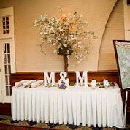 The image shows a table with a white tablecloth, adorned with decorative letters 