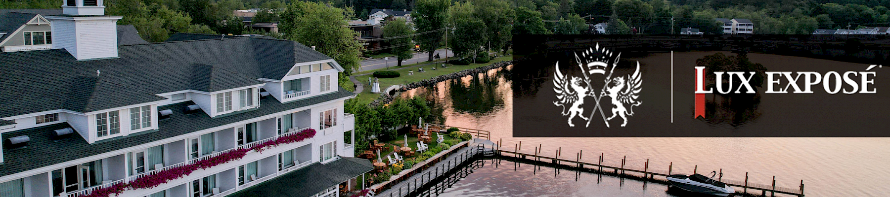 The image shows a large lakeside building at sunset, with 