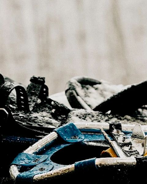 The image shows a set of snowshoes with straps lying on a snowy surface, ready for use in snow-covered terrain.